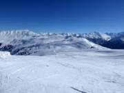 Blick über das Skigebiet Richtung Bergstation Wildkogelbahn und Hohe Tauern